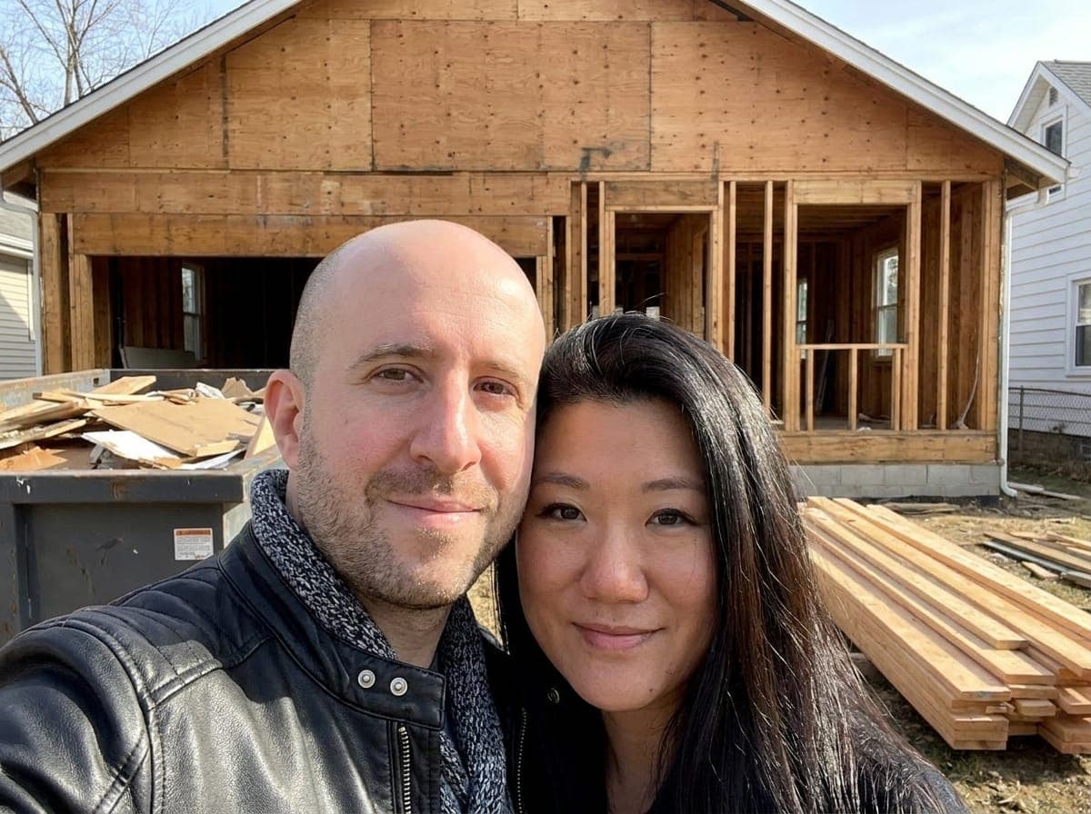 Nikita Levitan and Sabrina Gao of Nikita Buys Houses in front of a house under renovation